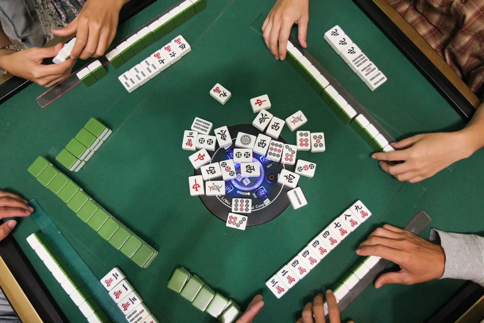 多人正在使用電動麻將桌進行麻將遊戲